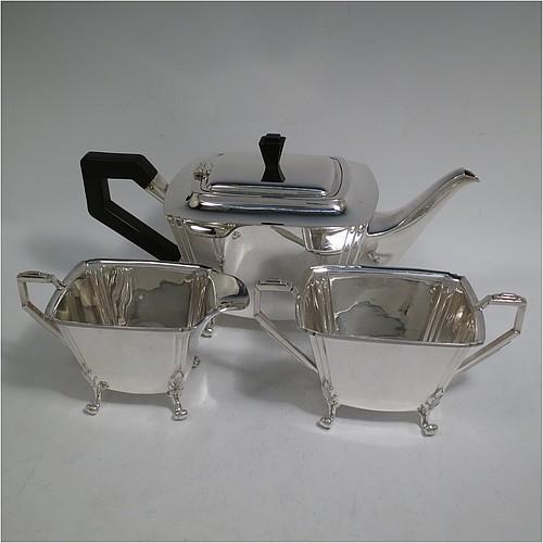 A very handsome and heavy Sterling Silver Art Deco three-piece tea set, consisting of a teapot, sugar bowl, and cream jug, in a plain rectangular panelled style with fluted corners, hand-cut stepped handles and matching finial, the teapot with a hinged lid, and all sitting on four cast scroll feet. Made by Joseph Gloster Ltd., of Birmingham in 1936. The dimensions of this fine hand-made Art Deco silver tea set are height of teapot 15 cms (6 inches), length 29 cms (11.3 inches), and it weighs a total of approx. 1,200g (39 troy ounces).