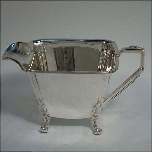 A very handsome and heavy Sterling Silver Art Deco three-piece tea set, consisting of a teapot, sugar bowl, and cream jug, in a plain rectangular panelled style with fluted corners, hand-cut stepped handles and matching finial, the teapot with a hinged lid, and all sitting on four cast scroll feet. Made by Joseph Gloster Ltd., of Birmingham in 1936. The dimensions of this fine hand-made Art Deco silver tea set are height of teapot 15 cms (6 inches), length 29 cms (11.3 inches), and it weighs a total of approx. 1,200g (39 troy ounces).