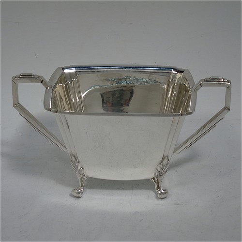 A very handsome and heavy Sterling Silver Art Deco three-piece tea set, consisting of a teapot, sugar bowl, and cream jug, in a plain rectangular panelled style with fluted corners, hand-cut stepped handles and matching finial, the teapot with a hinged lid, and all sitting on four cast scroll feet. Made by Joseph Gloster Ltd., of Birmingham in 1936. The dimensions of this fine hand-made Art Deco silver tea set are height of teapot 15 cms (6 inches), length 29 cms (11.3 inches), and it weighs a total of approx. 1,200g (39 troy ounces).