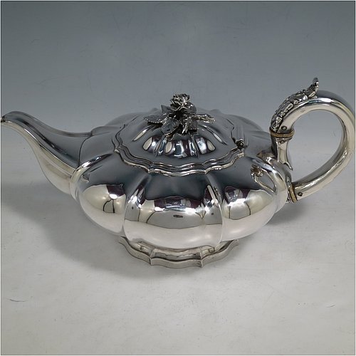 An Antique Georgian Sterling Silver three-piece tea set, having a teapot, sugar bowl and cream jug. The bodies all hand-chased with Melon style fluted decoration, the sugar and creamer with gold-gilt interiors and cast anthemion leaf handles, the teapot with silver insulated handle and cast rose finial, and all sitting on pedestal feet. Made by Rebecca Emes and John Barnard of London in 1826. The dimensions of this fine hand-made antique silver tea service are length of teapot 29 cms (11.5 inches), height 14 cms (5.5 inches), and it weighs a total of approx. 1,362g (44 troy ounces).    