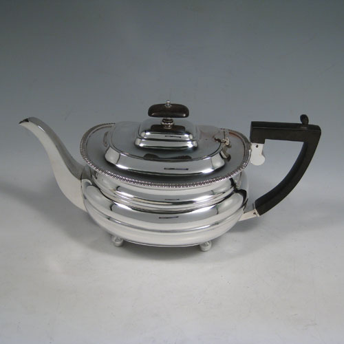 A handsome Antique Sterling silver three-piece tea and coffee set, having plain baluster bodies, applied gadroon borders, the teapot with hinged lid, wooden finial and handle, and all sitting on four ball feet. This elegant silver tea set was made by William Hutton of Sheffield in 1918. The dimensions of this fine hand-made antique silver tea service are length of teapot 29 cms (11.5 inches), height 15 cms (6 inches), and the total weight is approx. 1,147g (37 troy ounces).