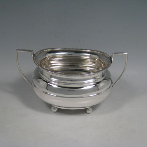 A handsome Antique Sterling silver three-piece tea and coffee set, having plain baluster bodies, applied gadroon borders, the teapot with hinged lid, wooden finial and handle, and all sitting on four ball feet. This elegant silver tea set was made by William Hutton of Sheffield in 1918. The dimensions of this fine hand-made antique silver tea service are length of teapot 29 cms (11.5 inches), height 15 cms (6 inches), and the total weight is approx. 1,147g (37 troy ounces).