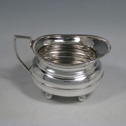 A handsome Antique Sterling silver three-piece tea and coffee set, having plain baluster bodies, applied gadroon borders, the teapot with hinged lid, wooden finial and handle, and all sitting on four ball feet. This elegant silver tea set was made by William Hutton of Sheffield in 1918. The dimensions of this fine hand-made antique silver tea service are length of teapot 29 cms (11.5 inches), height 15 cms (6 inches), and the total weight is approx. 1,147g (37 troy ounces).