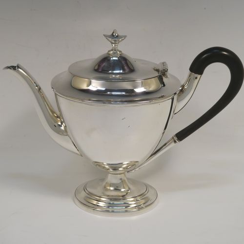 A very handsome Antique Edwardian Sterling Silver three-piece tea set, in a neoclassical style having plain oval shaped bodies, with loop side-handles, a wooden handle and finial on the teapot, and all sitting on oval pedestal feet. This elegant antique silver tea set was all made by Walker and Hall of Sheffield in 1908. The dimensions of this fine hand-made antique silver tea set are length of teapot 24 cms (9.5 inches), height 18.5 cms (7.25 inches), and the total weight is approx. 775g (25 troy ounces).   