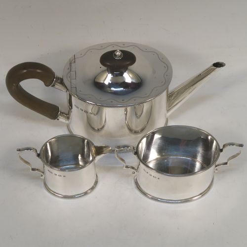 A very pretty Sterling Silver three-piece bachelor sized tea set, consisting of a teapot, sugar bowl, and cream jug, in a plain oval style with straight sides and applied bead-edged borders, the teapot with a brown wooden handle, finial, and a hinged domed lid with a flat invisible hinge, the sugar and creamer with scroll handles, and all sitting on flat bases. This beautiful silver bachelor size three-piece tea set was made by Roberts and Belk of Sheffield in 1940. The dimensions of this fine hand-made silver tea set are height of teapot 11.5 cms (4.5 inches), length 21.5 cms (8.5 inches), and it weighs a total of approx. 450g (14.5 troy ounces).  