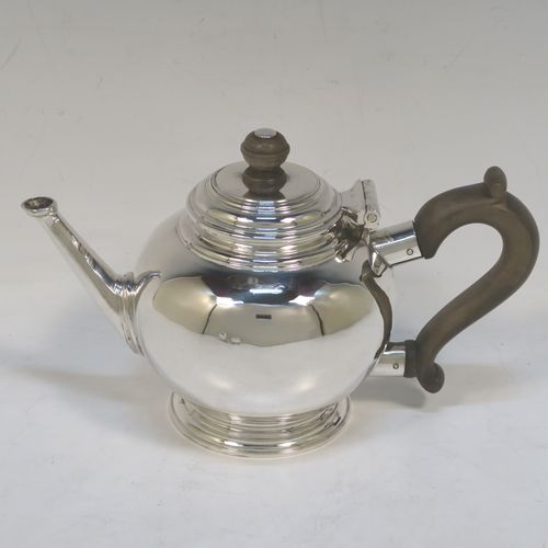 A heavy and very handsome Sterling Silver Bachelor three-piece tea set, having plain round bellied shaped bodies with reeded borders, the cream jug and sugar bowl with cast scroll side-handles, the teapot with a wooden handle and finial, and all sitting on round pedestal feet. This elegant silver bachelor tea set was all made by Robert Comyns of London in 1929. The dimensions of this fine hand-made and heavy silver bachelor tea set are length of teapot 20.5 cms (8 inches), height 11.5 cms (4.5 inches), and the total weight is approx. 807g (26 troy ounces).   