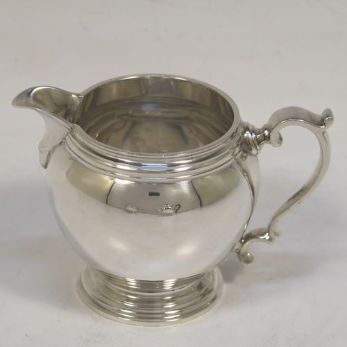 A heavy and very handsome Sterling Silver Bachelor three-piece tea set, having plain round bellied shaped bodies with reeded borders, the cream jug and sugar bowl with cast scroll side-handles, the teapot with a wooden handle and finial, and all sitting on round pedestal feet. This elegant silver bachelor tea set was all made by Robert Comyns of London in 1929. The dimensions of this fine hand-made and heavy silver bachelor tea set are length of teapot 20.5 cms (8 inches), height 11.5 cms (4.5 inches), and the total weight is approx. 807g (26 troy ounces).   