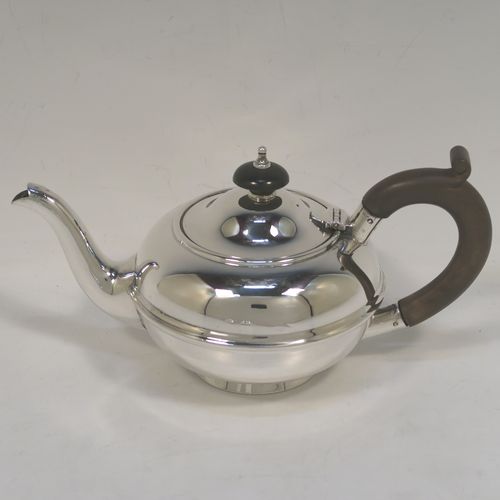 A very handsome Antique Sterling Silver Bachelor three-piece tea set, having plain round bellied shaped bodies, with central applied bands and loop handles, the teapot with a wooden handle and finial, and all sitting on round collet feet. This elegant antique silver bachelor tea set was all made by S. W. Smith and Co., of Birmingham in 1922. The dimensions of this fine hand-made antique silver bachelor tea set are length of teapot 20.5 cms (8 inches), height 10 cms (4 inches), and the total weight is approx. 468g (15 troy ounces).  