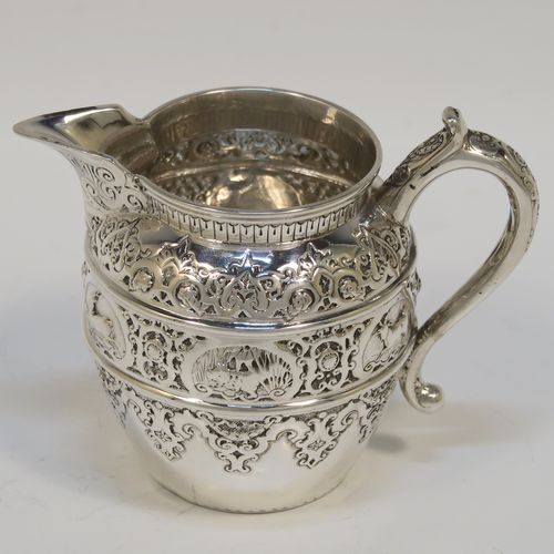 A very pretty Scottish Antique Victorian Sterling Silver three-piece bachelor tea set, having round bellied bodies with beautiful bands of hand-chased floral and animal decoration, with cast silver scroll side-handles, and all sitting on flat bases. This stunning antique silver tea set was made by John Rait of Glasgow in 1886. The dimensions of this fine hand-made antique silver bachelor tea set are height of teapot 13.5 cms (5.3 inches), length of teapot 19 cms (7.5 inches), with a total weight of approx. 558g (18 troy ounces).   