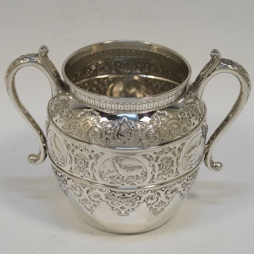 A very pretty Scottish Antique Victorian Sterling Silver three-piece bachelor tea set, having round bellied bodies with beautiful bands of hand-chased floral and animal decoration, with cast silver scroll side-handles, and all sitting on flat bases. This stunning antique silver tea set was made by John Rait of Glasgow in 1886. The dimensions of this fine hand-made antique silver bachelor tea set are height of teapot 13.5 cms (5.3 inches), length of teapot 19 cms (7.5 inches), with a total weight of approx. 558g (18 troy ounces).   