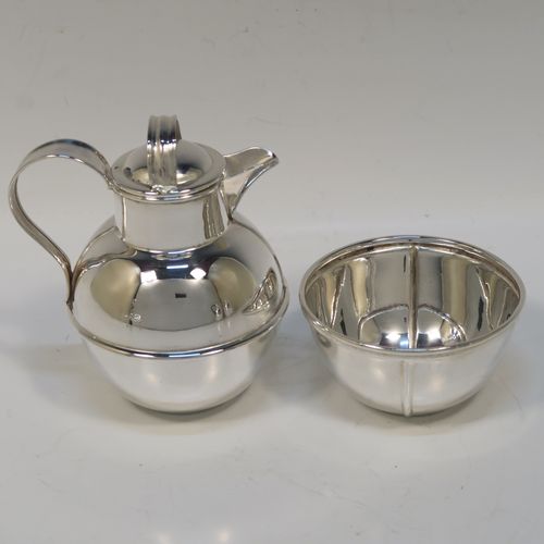 A very stylish and unusual Antique Edwardian Silver-Plated four-piece tea set in a Guernsey style, consisting of teapot, hot-water pot, sugar bowl, and cream jug, all in their original wire-work carrying stand. This beautiful antique silver plated tea set was made by James Collyer of Sheffield in ca. 1910. The dimensions of this fine hand-made antique silver-plated Guernsey tea set and carrying frame are height 21 cms (8.25 inches), length 26.5 cms (10.5 inches), and width 18 cms (7 inches).   