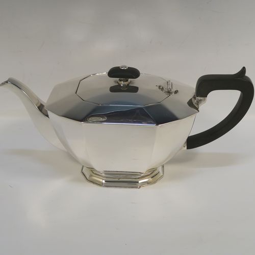 A very handsome Sterling Silver Art Deco style  three-piece tea set, consisting of a teapot, sugar bowl, and cream jug, having plain panelled bodies and angular handles, the teapot with a black wooden handle, finial, and a hinged lid, and all sitting on collet feet. This elegant silver tea set was made by the Cooper Brothers of Sheffield in 1966. The dimensions of this fine hand-made Art Deco style silver tea set are height of teapot 13.5 cms (5.3 inches), length 28 cms (11 inches), and it weighs a total of approx. 1,062g (34 troy ounces).   