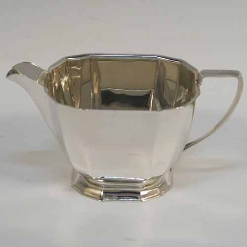 A very handsome Sterling Silver Art Deco style  three-piece tea set, consisting of a teapot, sugar bowl, and cream jug, having plain panelled bodies and angular handles, the teapot with a black wooden handle, finial, and a hinged lid, and all sitting on collet feet. This elegant silver tea set was made by the Cooper Brothers of Sheffield in 1966. The dimensions of this fine hand-made Art Deco style silver tea set are height of teapot 13.5 cms (5.3 inches), length 28 cms (11 inches), and it weighs a total of approx. 1,062g (34 troy ounces).   