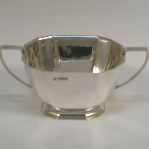 A very handsome Sterling Silver Art Deco style  three-piece tea set, consisting of a teapot, sugar bowl, and cream jug, having plain panelled bodies and angular handles, the teapot with a black wooden handle, finial, and a hinged lid, and all sitting on collet feet. This elegant silver tea set was made by the Cooper Brothers of Sheffield in 1966. The dimensions of this fine hand-made Art Deco style silver tea set are height of teapot 13.5 cms (5.3 inches), length 28 cms (11 inches), and it weighs a total of approx. 1,062g (34 troy ounces).   