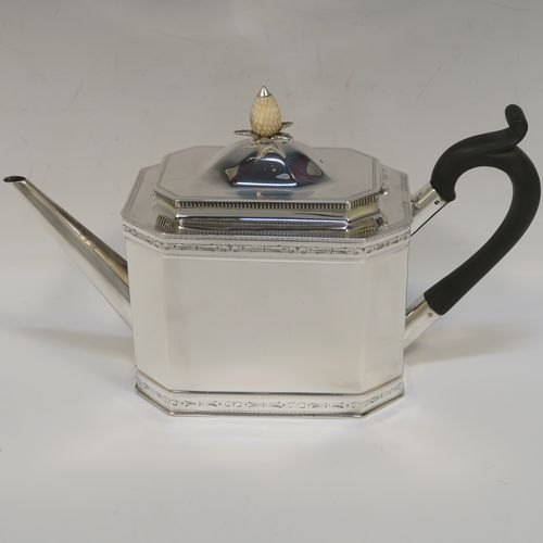 A heavy Sterling Silver three-piece tea set, in a neoclassical style, having plain octagonal bodies with straight sides, applied bead-edged borders above and below bands of bright-cut engraving, with flat-topped scroll side-handles, the teapot with a black wooden scroll handle and a domed lid with bone pineapple finial, and all sitting on flat bases. This beautiful silver three-piece tea set was made by Mappin and Webb of  Sheffield in 1926. The dimensions of this fine hand-made silver tea set are length of teapot 26 cms (10.75 inches), height 13.5 cms (5.3 inches), and the total weight is approx. 1,100g (35.5 troy ounces).   