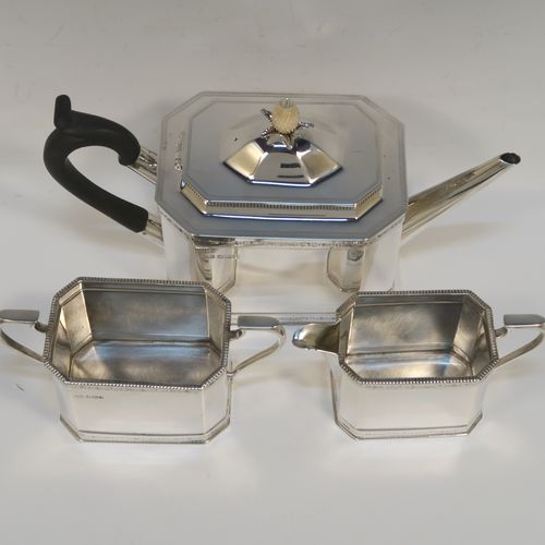 A heavy Sterling Silver three-piece tea set, in a neoclassical style, having plain octagonal bodies with straight sides, applied bead-edged borders above and below bands of bright-cut engraving, with flat-topped scroll side-handles, the teapot with a black wooden scroll handle and a domed lid with bone pineapple finial, and all sitting on flat bases. This beautiful silver three-piece tea set was made by Mappin and Webb of  Sheffield in 1926. The dimensions of this fine hand-made silver tea set are length of teapot 26 cms (10.75 inches), height 13.5 cms (5.3 inches), and the total weight is approx. 1,100g (35.5 troy ounces).   