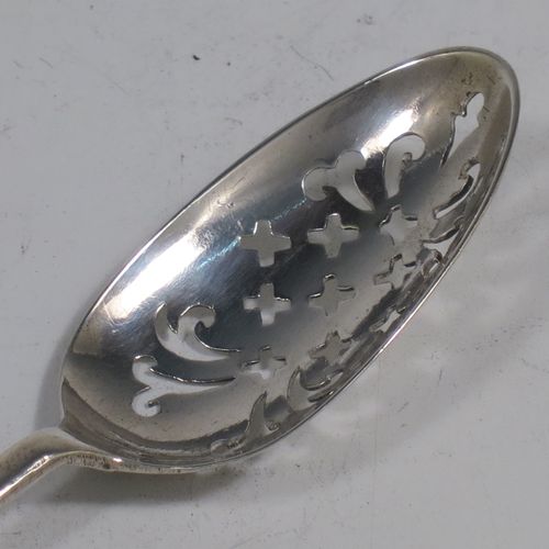 A rare Antique Georgian Sterling Silver mote tea strainer spoon, having a hand-pierced oval bowl with scroll and hatched decoration, the reverse with hand-chased floral and scroll picture-back decoration, and with a handle having a pointed end for clearing teapot spouts. Made in London in ca. 1770. The dimensions of this fine hand-made antique silver mote spoon are length 13 cms (5 inches), and width of bowl 2.3 cms (0.8 inches).   