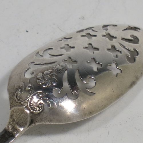 A rare Antique Georgian Sterling Silver mote tea strainer spoon, having a hand-pierced oval bowl with scroll and hatched decoration, the reverse with hand-chased floral and scroll picture-back decoration, and with a handle having a pointed end for clearing teapot spouts. Made in London in ca. 1770. The dimensions of this fine hand-made antique silver mote spoon are length 13 cms (5 inches), and width of bowl 2.3 cms (0.8 inches).   