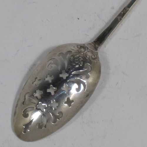 A rare Antique Georgian Sterling Silver mote tea strainer spoon, having a hand-pierced oval bowl with scroll and hatched decoration, the reverse with hand-chased floral and scroll picture-back decoration, and with a handle having a pointed end for clearing teapot spouts. Made in London in ca. 1770. The dimensions of this fine hand-made antique silver mote spoon are length 13 cms (5 inches), and width of bowl 2.3 cms (0.8 inches).   