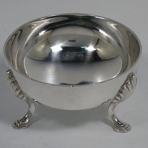 A very handsome, large, and heavy Sterling Silver tea strainer and bowl, having a plain wood-turned handle, a round hand-pierced bowl with an applied reeded border and a cast shell side holder, and sitting on a plain round dregs bowl with three cast hoof feet and shell shoulders. Made by Robert Comyns of London in 1964. The dimensions of this fine hand-made silver tea strainer & bowl are length 19 cms (7.5 inches), diameter of bowl 8 cms (3 inches), with a total weight of approx. 155g (5 troy ounces).    