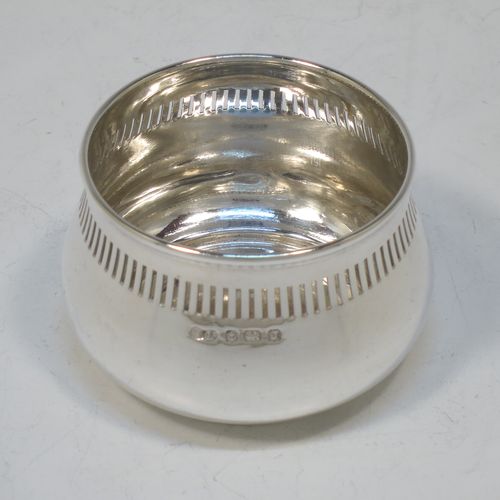 A pretty Sterling Silver tea strainer and bowl, having a hand-pierced handle, a round hand-pierced bowl with hand-cut side holder, and sitting on a plain round dregs stand with a band of piercing and bellied sides. Made by William Suckling Ltd., of Birmingham in 1933. The dimensions of this fine hand-made silver tea strainer & stand are length 14.5 cms (5.75 inches), diameter of stand 6 cms (2.3 inches), with a total weight of approx. 75g (2.4 troy ounces).  