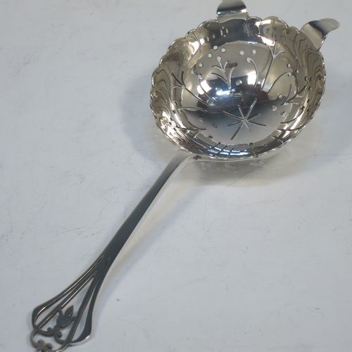 A very pretty Sterling Silver tea strainer and bowl, having a floral hand-pierced handle, a round hand-pierced bowl with two side holder lugs, and sitting on a plain round dregs bowl with a hand-chased middle band. Made by Frances Howard of Sheffield in 1923. The dimensions of this fine hand-made silver tea strainer & bowl are length 15 cms (6 inches), diameter of bowl 6.5 cms (2.5 inches), with a total weight of approx. 87g (2.8 troy ounces).   