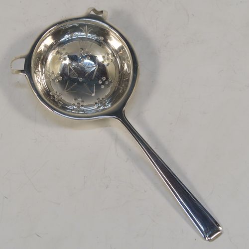 A very elegant Sterling Silver tea strainer and bowl in an Art Deco style, having an Athenian pattern handle, a round hand-pierced bowl with two side holder lugs, and sitting on a plain round dregs bowl with three flange feet. This handsome Art Deco silver tea strainer was made by Cooper Brothers of Sheffield in 1937. The dimensions of this fine hand-made silver tea strainer & bowl are length 15 cms (6 inches), diameter of bowl 6.5 cms (2.5 inches), with a total weight of approx. 98g (3.2 troy ounces).  