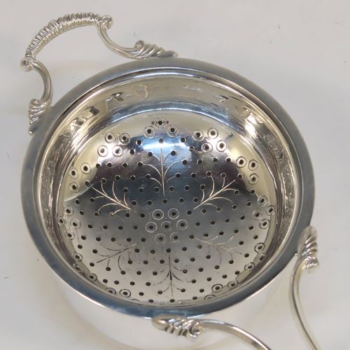 A very pretty Sterling Silver tea strainer and bowl, having a cast scroll side-handle, a round hand-pierced and engraved bowl, and sitting on a plain round dregs bowl. This elegant silver tea strainer and bowl made by Suckling Ltd. of Birmingham in 1958. The dimensions of this fine hand-made silver tea strainer & bowl are length 14 cms (5.5 inches), diameter of bowl 7 cms (2.75 inches), with a total weight of approx. 87g (2.8 troy ounces).   