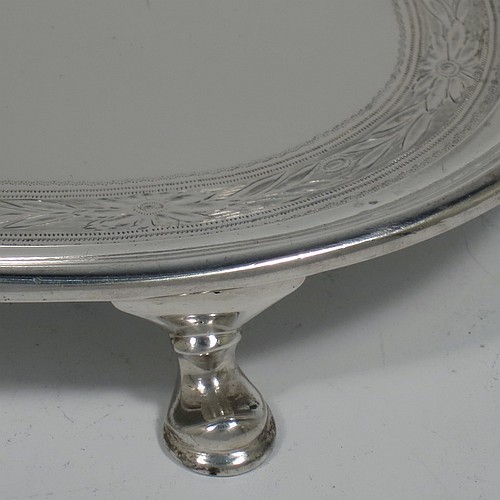 A very handsome Antique Edwardian Sterling Silver teapot stand, having an oval body with a band of hand-engraved floral decoration, a raised border with an applied reeded edge, and sitting on four cast hoof feet. Made by the Pairpoint Brothers of London in 1905. The dimensions of this fine hand-made antique silver teapot stand are length 17.5 cms (7 inches), width 13 cms (5 inches), and it weighs approx. 238g (7.8 troy ounces).    