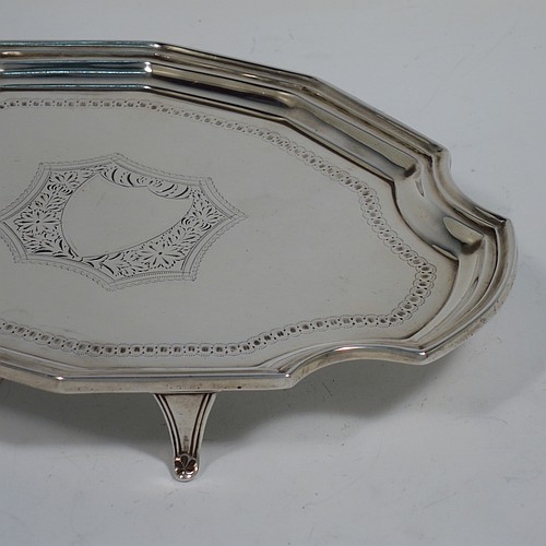 An Antique Victorian Scottish Sterling Silver teapot stand, having a shaped and cut-cornered oval body with an applied reeded border, the flat ground with a hand-engraved beaded band surrounding a central vacant cartouche, and all sitting on four flange feet. Made by Hamilton & Inches of Edinburgh in 1883. The dimensions of this fine hand-made antique silver teapot stand are length 18 cms (7 inches), width 13 cms (5 inches), and it weighs approx. 150g (4.8 troy ounces).   