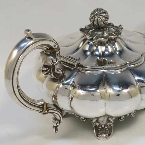 A very pretty Antique early Victorian Sterling Silver teapot, in the Melon fluted style having a round bellied body, a curved tapering spout, an original silver handle with bone insulator inserts, a domed hinged lid with an original cast pomegranate and leaf finial, and all sitting on four cast foliate and shell feet. This beautiful antique silver Melon fluted teapot was made by Charles Lias of London in 1840. The dimensions of this fine hand-made antique silver teapot are length 27.5 cms (10.75 inches), height 15 cms (6 inches), and it weighs approx. 763g (24.6 troy ounces).   