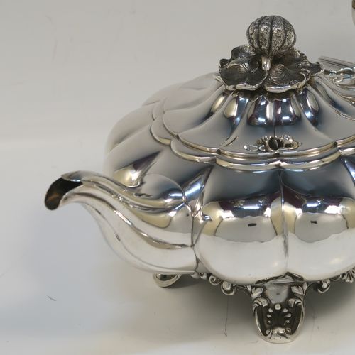 A very pretty Antique early Victorian Sterling Silver teapot, in the Melon fluted style having a round bellied body, a curved tapering spout, an original silver handle with bone insulator inserts, a domed hinged lid with an original cast pomegranate and leaf finial, and all sitting on four cast foliate and shell feet. This beautiful antique silver Melon fluted teapot was made by Charles Lias of London in 1840. The dimensions of this fine hand-made antique silver teapot are length 27.5 cms (10.75 inches), height 15 cms (6 inches), and it weighs approx. 763g (24.6 troy ounces).   