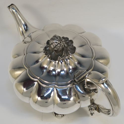 A very pretty Antique early Victorian Sterling Silver teapot, in the Melon fluted style having a round bellied body, a curved tapering spout, an original silver handle with bone insulator inserts, a domed hinged lid with an original cast pomegranate and leaf finial, and all sitting on four cast foliate and shell feet. This beautiful antique silver Melon fluted teapot was made by Charles Lias of London in 1840. The dimensions of this fine hand-made antique silver teapot are length 27.5 cms (10.75 inches), height 15 cms (6 inches), and it weighs approx. 763g (24.6 troy ounces).   