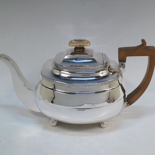 A very handsome Antique Georgian Sterling Silver teapot, having a rectangular bellied body with hand-chased reeded decoration and applied upper gadroon borders, a brown wooden handle with thumb-piece, a domed lid with a bone finial and a flat invisible hinge, a plain square cross-section spout, and all sitting on four ball feet. Made by William Bennett of London in 1811. The dimensions of this fine hand-made antique silver teapot are length 28 cms (11 inches), width 12.5 cms (5 inches), height 15 cms (6 inches), and it weighs approx. 558g (18 troy ounces).   