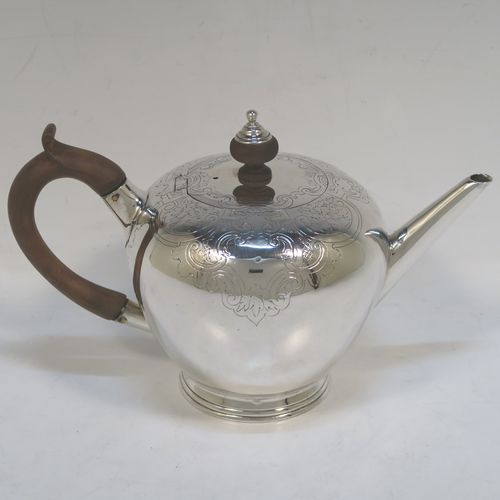 A very handsome Antique Georgian sterling silver teapot in an early George II Bullet style, having a  round bellied body with hand-chased scroll and floral decoration on the top, a straight tapering spout, a wooden scroll handle and finial, an invisibly hinged flat lid, and sitting on a collet foot. This elegant antique silver Bullet teapot was made by David Hennell I of London in 1749. The dimensions of this fine hand-made antique silver teapot are length 20 cms (8 inches), height 11 cms (4.3 inches), and it weighs approx. 350g (11.3 troy ounces).  