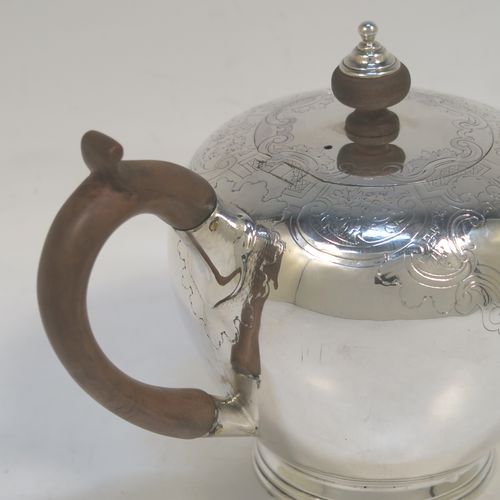 A very handsome Antique Georgian sterling silver teapot in an early George II Bullet style, having a  round bellied body with hand-chased scroll and floral decoration on the top, a straight tapering spout, a wooden scroll handle and finial, an invisibly hinged flat lid, and sitting on a collet foot. This elegant antique silver Bullet teapot was made by David Hennell I of London in 1749. The dimensions of this fine hand-made antique silver teapot are length 20 cms (8 inches), height 11 cms (4.3 inches), and it weighs approx. 350g (11.3 troy ounces).  