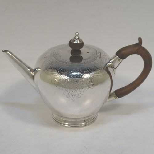 A very handsome Antique Georgian sterling silver teapot in an early George II Bullet style, having a  round bellied body with hand-chased scroll and floral decoration on the top, a straight tapering spout, a wooden scroll handle and finial, an invisibly hinged flat lid, and sitting on a collet foot. This elegant antique silver Bullet teapot was made by David Hennell I of London in 1749. The dimensions of this fine hand-made antique silver teapot are length 20 cms (8 inches), height 11 cms (4.3 inches), and it weighs approx. 350g (11.3 troy ounces).  