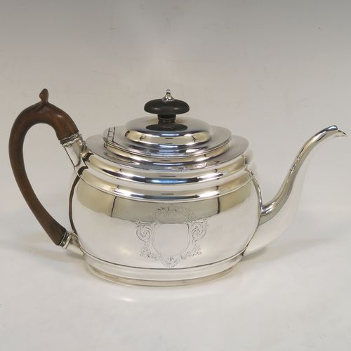 A very handsome Antique Georgian Sterling Silver teapot, having a plain oval body with curved sides and reeded decoration, with engraved vacant cartouches on both sides, a curved tapering spout, a wooden scroll handle and finial, an invisibly hinged domed lid, and all sitting on a flat base. This elegant Georgian silver teapot was made by Soloman Hougham of London in 1800. The dimensions of this fine hand-made antique silver teapot are length 28 cms (11 inches), height 16 cms (6.3 inches), and it weighs approx. 450g (14.5 troy ounces).  