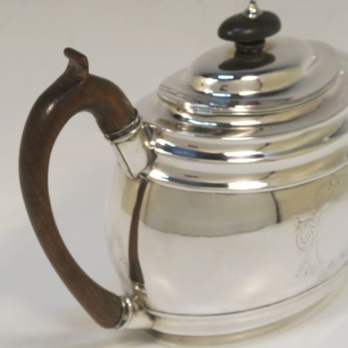 A very handsome Antique Georgian Sterling Silver teapot, having a plain oval body with curved sides and reeded decoration, with engraved vacant cartouches on both sides, a curved tapering spout, a wooden scroll handle and finial, an invisibly hinged domed lid, and all sitting on a flat base. This elegant Georgian silver teapot was made by Soloman Hougham of London in 1800. The dimensions of this fine hand-made antique silver teapot are length 28 cms (11 inches), height 16 cms (6.3 inches), and it weighs approx. 450g (14.5 troy ounces).  