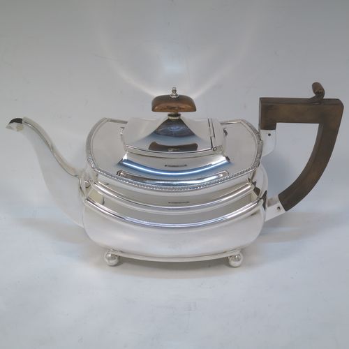 A very handsome Sterling Silver teapot, having a rectangular bellied body with two hand-chased girdle bands and an applied upper gadroon border, a brown wooden handle with thumb-piece, a domed lid with wooden finial, a plain square cross-section spout, and all sitting on four ball feet. Made by S. Blankensee and Sons of Chester in 1933. The dimensions of this fine hand-made silver teapot are length 27 cms (10.5 inches), width 13 cms (5 inches), height 15 cms (6 inches), and it weighs approx. 698g (22.5 troy ounces).   