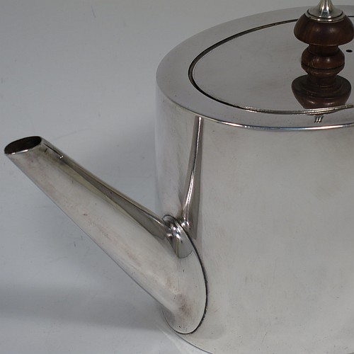 A very handsome Neoclassical style Antique Georgian Sterling Silver teapot in a Bachelor size for two people, having a very plain oval straight-sided body, a straight tapering spout, a wooden scroll handle and round finial, an invisibly hinged flat lid, and all sitting on a flat base. Made by Charles Aldridge and Henry Green of London in 1780. The dimensions of this fine hand-made antique silver bachelor teapot are length 23 cms (9 inches), height 12 cms (4.75 inches), and it weighs approx. 310g (31 troy ounces).    