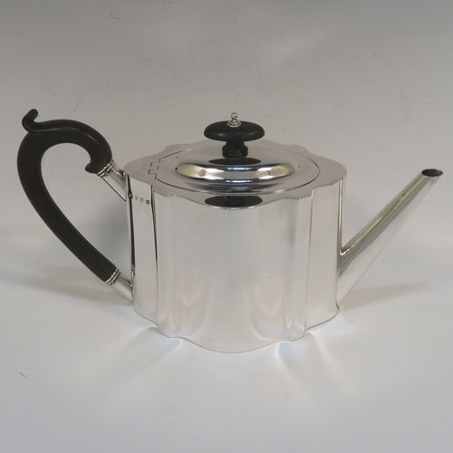 A very handsome Neoclassical style Antique Sterling Silver teapot, having a plain shaped oval straight-sided body, a straight tapering spout, a wooden scroll handle and oval finial, an invisibly hinged domed lid, and all sitting on a flat base. This elegant antique silver teapot was made by Thomas Wooley of Birmingham in 1914. The dimensions of this fine hand-made antique silver teapot are length 27 cms (10.5 inches), height 14 cms (5.5 inches), and it weighs approx. 495g (16 troy ounces).    