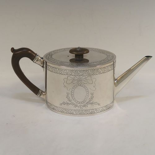 A very elegant Neoclassical style Antique Georgian Sterling Silver teapot, having an oval straight-sided body with hand-engraved upper and lower bands of floral work, with an oval engraved cartouche on one side, a straight tapering spout, a wooden scroll handle and oval finial, an invisibly hinged flat lid with matching engraving, and all sitting on a flat base. This beautiful antique silver teapot was made by Charles Aldridge and Henry Green of London in 1782. The dimensions of this fine hand-made antique silver teapot are length 26 cms (10.25 inches), height 11.5 cms (4.5 inches), and it weighs approx. 375g (12 troy ounces).  