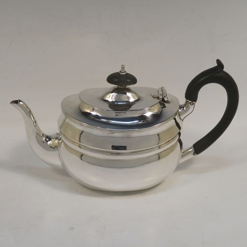 A very handsome Antique Sterling Silver teapot, having a plain oval body with curved sides and reeded decoration, a curved tapering spout, a wooden scroll handle and finial, a hinged domed lid, and all sitting on a flat base. This elegant silver teapot was made by Nathan and Hayes of Chester in 1912. The dimensions of this fine hand-made antique silver teapot are length 23 cms (9 inches), height 12.5 cms (5 inches), and it weighs approx. 350g (11.3 troy ounces).  