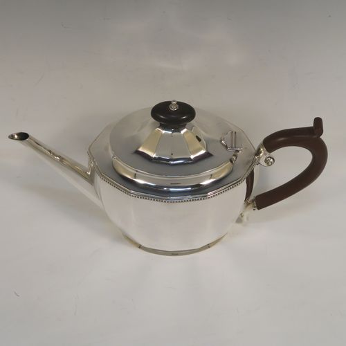 A very handsome Sterling Silver teapot, having a plain oval body with paneled curved sides and an applied gadroon border, a straight tapering spout, a wooden scroll handle and finial, and all sitting on a flat base. This elegant silver teapot was made by Alexander Clarke of Birmingham in 1932. The dimensions of this fine hand-made silver teapot are length 28 cms (11 inches), height 16.5 cms (6.5 inches), and it weighs approx. 530g (17 troy ounces).  