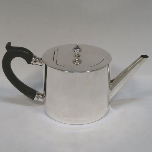 A very stylish and handsome Antique Victorian Sterling Silver teapot, having a very plain round straight-sided body, a straight tapering spout, a wooden scroll handle, an invisibly hinged flat  lid with a cast round finial, and all sitting on a flat base. This beautiful antique silver teapot was made by Charles Stuart Harris of London in 1870. The dimensions of this fine hand-made antique silver teapot are length 23 cms (9 inches), height 11.5 cms (4.5 inches), diameter of main body 11 cms (4.3 inches), and it weighs approx. 450g (14.5 troy ounces).