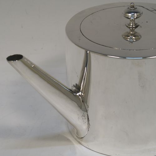 A very stylish and handsome Antique Victorian Sterling Silver teapot, having a very plain round straight-sided body, a straight tapering spout, a wooden scroll handle, an invisibly hinged flat  lid with a cast round finial, and all sitting on a flat base. This beautiful antique silver teapot was made by Charles Stuart Harris of London in 1870. The dimensions of this fine hand-made antique silver teapot are length 23 cms (9 inches), height 11.5 cms (4.5 inches), diameter of main body 11 cms (4.3 inches), and it weighs approx. 450g (14.5 troy ounces).