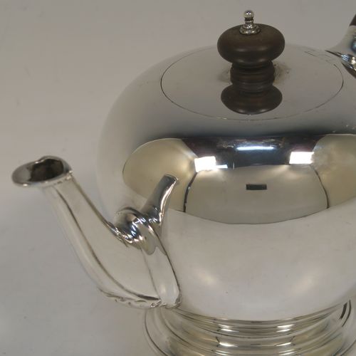 A very handsome Sterling Silver teapot in an early George II Bullet or Skittle Ball style, having a very plain round bellied body, a straight tapering spout, a wooden scroll handle and finial, an invisibly hinged flat lid, and sitting on a pedestal foot. This elegant silver teapot was made by D. and J. Welby of London in 1927. The dimensions of this fine hand-made silver skittle ball style teapot are length 22.5 cms (8.75 inches), height 13 cms (5 inches), and it weighs approx. 500g (16 troy ounces). Please note that this item is crested on one side.