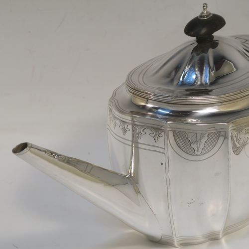 A very pretty Antique Georgian Sterling Silver teapot, having an oval panelled body with curved sides, an upper band of hand-engraved floral and scroll decoration, a plain straight tapering spout, a wooden scroll handle and finial, an invisibly hinged domed lid, and all sitting on a flat base. This elegant Georgian silver teapot was made by Soloman Hougham of London in 1798. The dimensions of this fine hand-made antique silver teapot are length 32 cms (12.5 inches), height 16 cms (6.3 inches), and it weighs approx. 450g (14.5 troy ounces).   