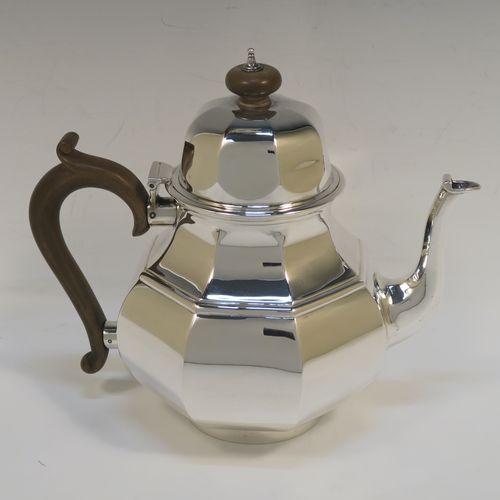 A heavy Antique Sterling Silver George I style large teapot, having a plain panelled bellied body, with a wooden scroll handle, a hinged domed lid with wooden  finial, a panelled spout, and all sitting on a collet foot. This handsome antique silver teapot was made by D. and J. Welby of London in 1918. The dimensions of this fine hand-made silver teapot are height 19 cms (7.5 inches), length 23 cms (9 inches), and the weight is approx. 700g (22.6 troy ounces).   